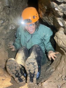 Une participante du parcours spéléo famille dans la partie étroite de l'entrée de la Grotte des Croix Blanches à Vinezac, en Ardèche